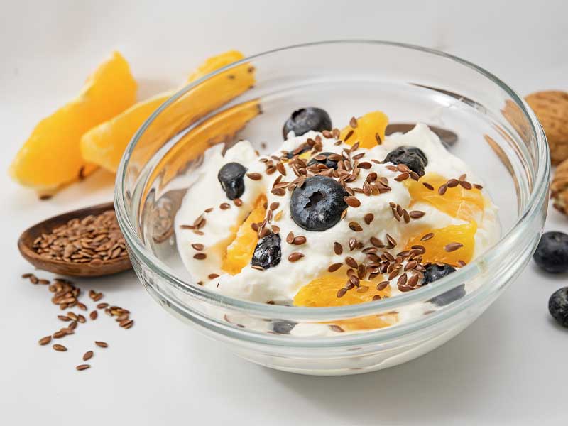 Die Faustregel für einen definierten Bauch lautet: weniger Kohlenhydrate, mehr Proteine., wie z. B. bei diesem gesunden fettarmen Joghurt mit Früchten