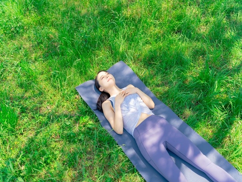 Bei der Schlussentspannung beim Outdoor-Yoga kommst du zur Ruhe und genießt einen Moment die Natur um dich herum.