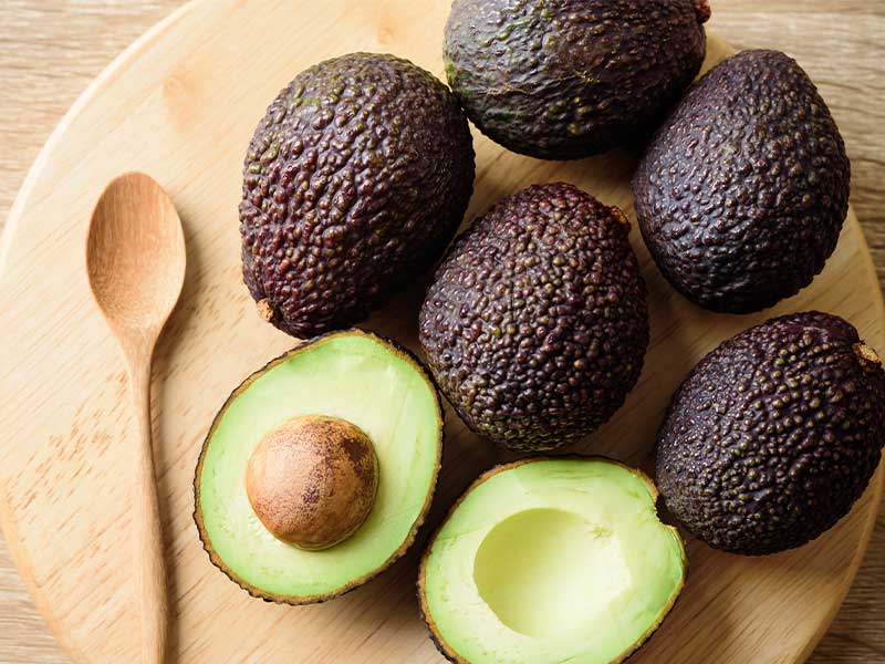 Hass-Avocado: Die Schale ist unreif grün und reift mit der Zeit dunkelbraun-violett. Ihre genoppte, ledrige Hülle hat den Spitznamen „Alligator-Frucht“.