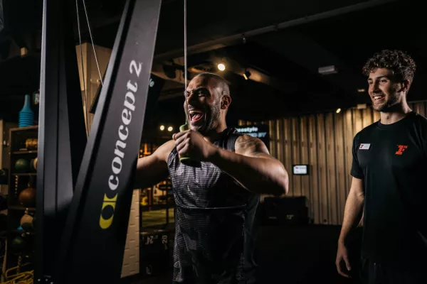 Trainer motiviert Mann am Ski-Ergometer