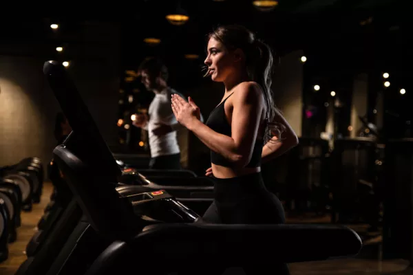 Junge Frau trainiert auf dem Laufband